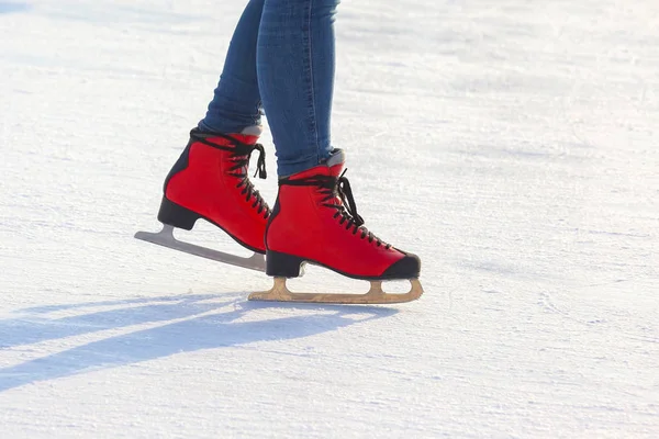 Patas femeninas en patines en una pista de hielo. Deporte y entretenimiento. R —  Fotos de Stock