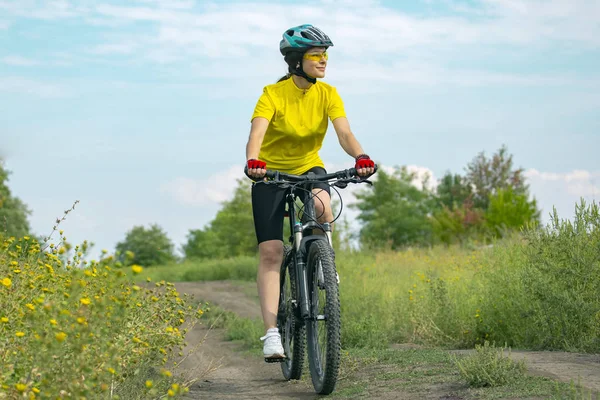 Schönes Mädchen in Gelb, das in der Natur Fahrrad fährt. Sport und rec — Stockfoto