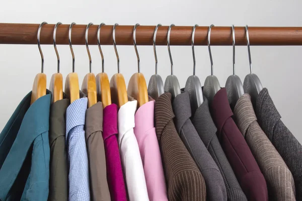 Diferentes chaquetas clásicas de oficina de las mujeres y camisas cuelgan en una ha —  Fotos de Stock