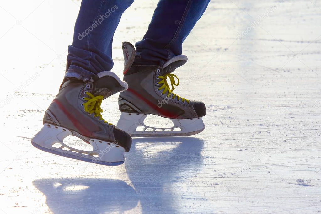 legs of a man skating on an ice rink. Sport and entertainment. R