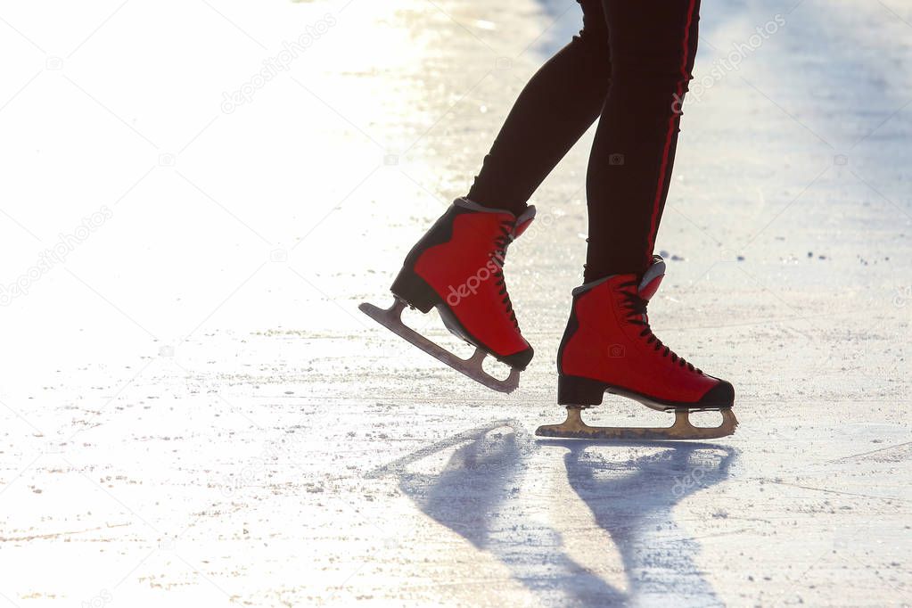 feet in red skates on an ice rink. Sport and entertainment. Rest