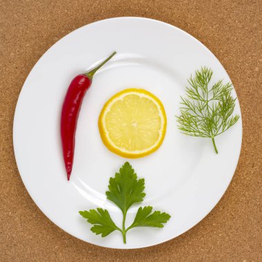 Limonlu kırmızı biber ve beyaz tabakta bitkiler. Sağlıklı ve