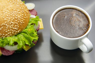 Sebzeli hamburger, sosis ve gri sırtlı kahve.