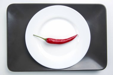 Beyaz tabakta kırmızı biber. Baharat ve sebze. Baharatlı fo