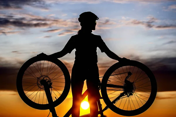 自転車を背景に自転車を持つ少女サイクリストのシルエット — ストック写真