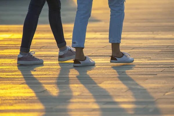 Ноги людей, що ходять на заході сонця. Дозвілля та відпочинок в — стокове фото