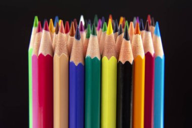 Koyu bir arkaplana çizim yapmak için renkli kalemler. Eğitim ve 