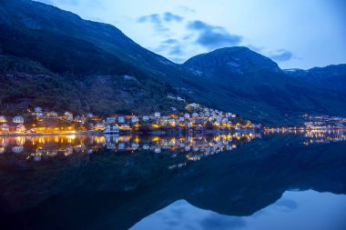 Gece şehir Odda su yansıması. Norveç