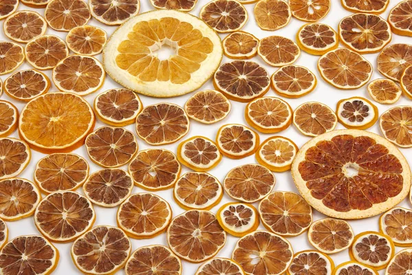 Torkade skivor av olika citrusfrukter på vit bakgrund — Stockfoto