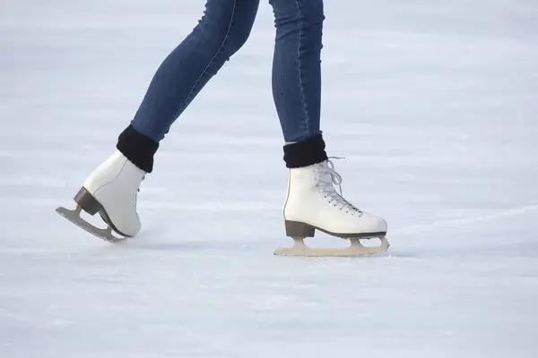 Beine eines Mädchen beim Schlittschuhlaufen auf einer Eisbahn — Stockfoto