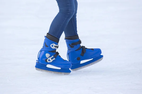穿着蓝色冰鞋的人的腿骑在溜冰场上。 业余爱好和爱好 — 图库照片