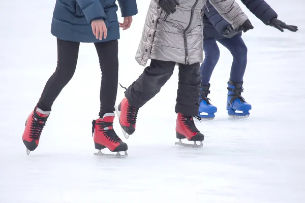 Diferentes personas están patinando activamente en una pista de hielo. Pasatiempos y — Foto de Stock