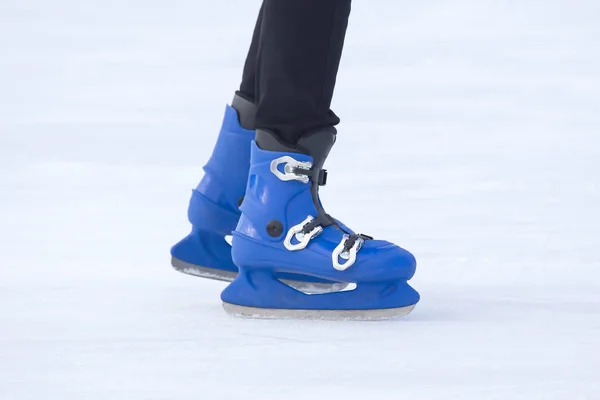 穿着蓝色冰鞋的人的腿骑在溜冰场上。 业余爱好和爱好 — 图库照片