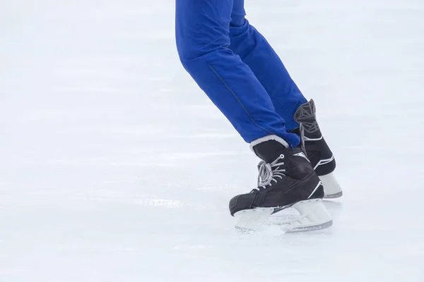 Piernas de un hombre patinando en una pista de hielo. Pasatiempos y deportes. Vacati. — Foto de Stock