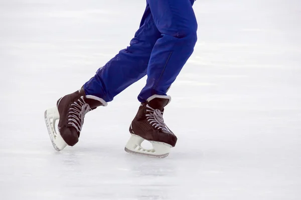 Piernas de un hombre patinando en una pista de hielo. Pasatiempos y deportes. Vacati. — Foto de Stock