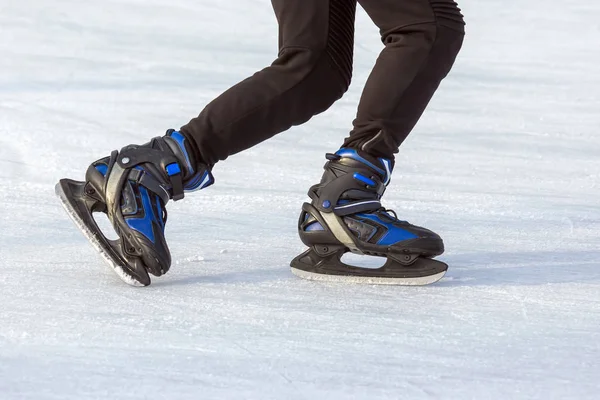 Hombre patina activamente en una pista de hielo. Pasatiempos y deportes. Vacaciones — Foto de Stock