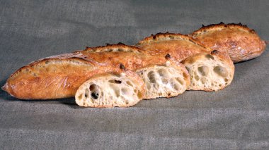 Uzun kesilmiş beyaz ekmek yalanlar üzerine bir gri keten masa örtüsü