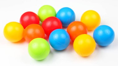 Beyaz arkaplanda renkli plastik toplar