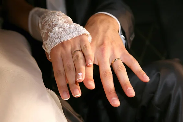 Noiva e noivo mostrar suas mãos usando anéis de casamento — Fotografia de Stock