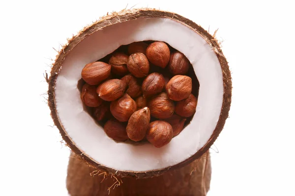 Avelãs em um coco dividido no fundo branco — Fotografia de Stock
