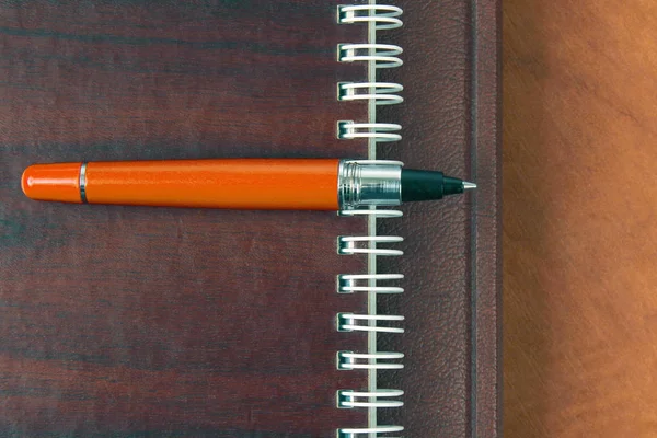 Notizbuch und roter Stift liegen auf Holztisch — Stockfoto