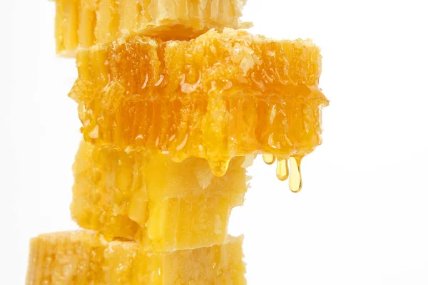 Honey flowing from the honeycombs on a light background — Stock Photo, Image