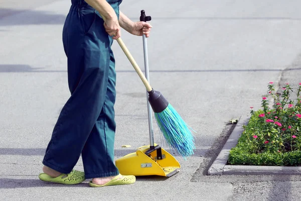 the janitor sweeping broom street