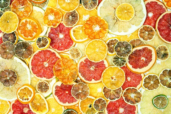 Blanda olika bitar av torkade citrusfrukter på vita bak — Stockfoto