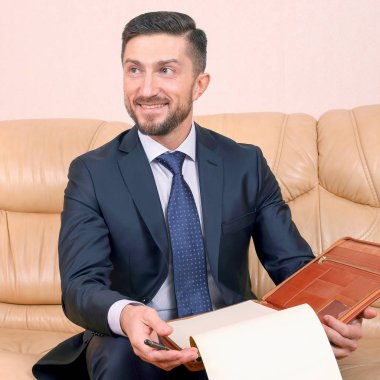 Başarılı bir iş adamı üzerine oturduğu iş belgeleriyle meşgul.