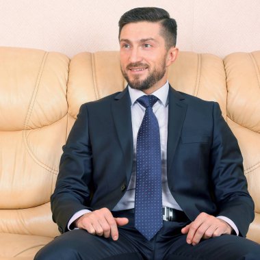 bir deri kanepede oturan başarılı iş adamı
