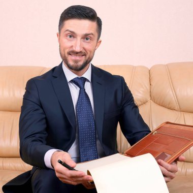 Başarılı bir iş adamı üzerine oturduğu iş belgeleriyle meşgul.
