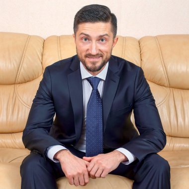 bir deri kanepede oturan başarılı iş adamı