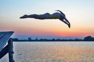 Bir kız akşamları suya atlama silüeti