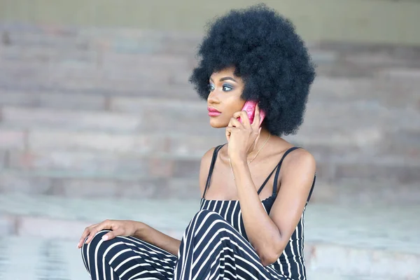 Модная и красивая африканская девушка в полосатой одежде говорит — стоковое фото