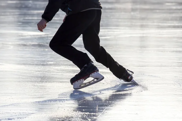 Stock image man actively skates on an ice rink.