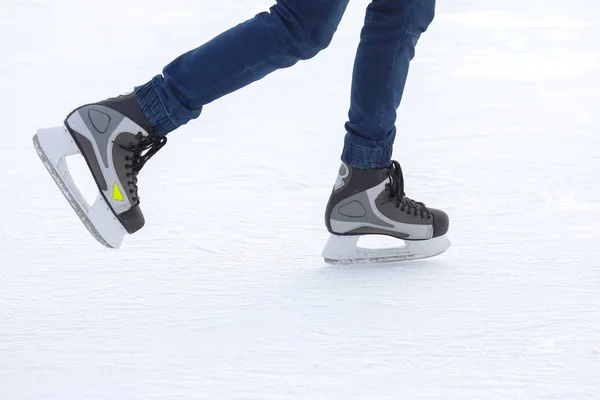 Piernas de un hombre patinando en una pista de hielo. Pasatiempos y deportes. Vacati. — Foto de Stock