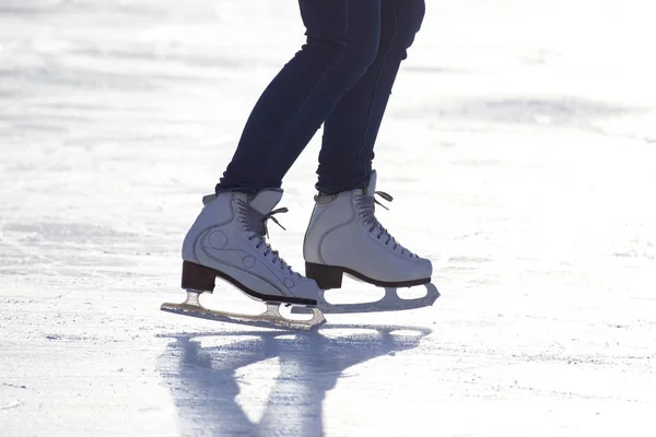 Pernas de uma menina patinação no gelo em uma pista de gelo. Passatempos e desportos. V — Fotografia de Stock