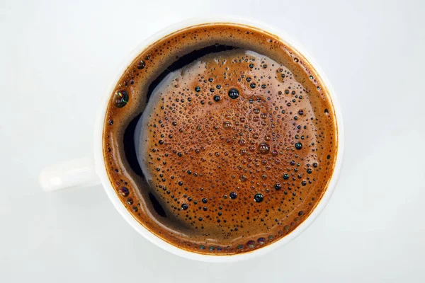 Café recién hecho en una taza sobre fondo blanco primer plano —  Fotos de Stock