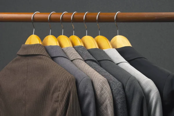 Different women's office classic jackets hang on a hanger for st