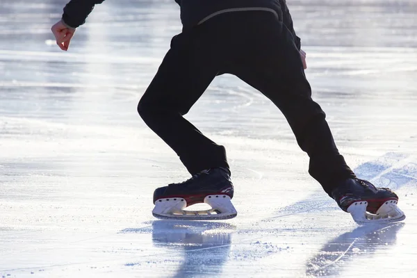 Voeten op de schaatsen van een persoon rollend op de ijsbaan — Stockfoto