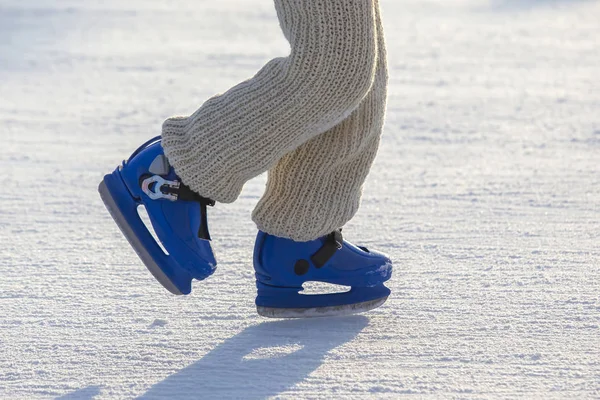 Pernas de um homem de patins azuis passeios em uma pista de gelo. Hobbies e s — Fotografia de Stock