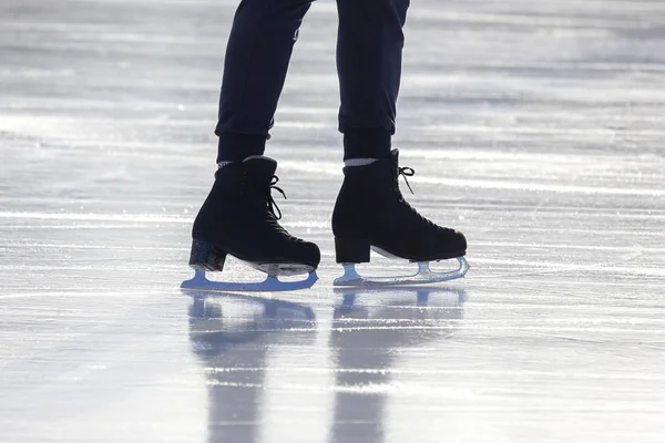 Pés nos patins de uma pessoa rolando na pista de gelo — Fotografia de Stock