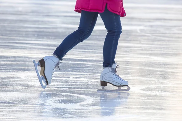 Piernas de una chica patinando sobre hielo en una pista de hielo. Pasatiempos y deportes. V. — Foto de Stock