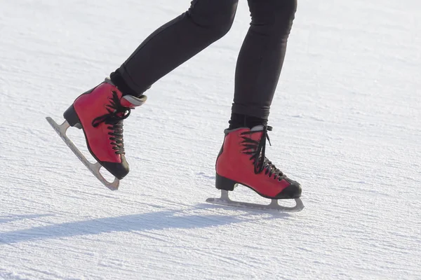 Buz pistinde kırmızı paten giyen ayaklar. Hobiler ve spor. Tatiller — Stok fotoğraf