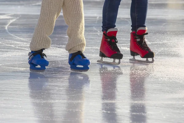 Pies de diferentes personas patinando en la pista de hielo —  Fotos de Stock