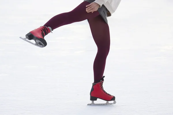 Pernas de uma menina patinação no gelo em uma pista de gelo — Fotografia de Stock