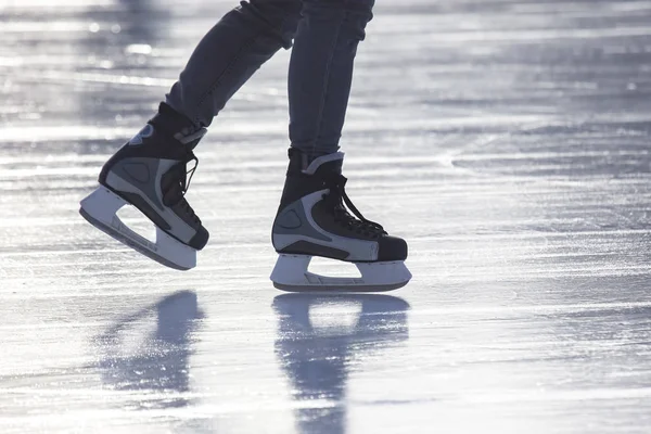 Piernas de un hombre patinando en una pista de hielo. Pasatiempos y deportes. Vacati. — Foto de Stock