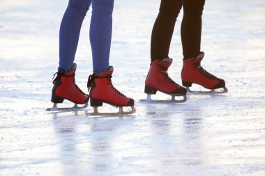 Buz pistinde kırmızı paten giyen ayaklar. Hobiler ve boş vakitler. Kış
