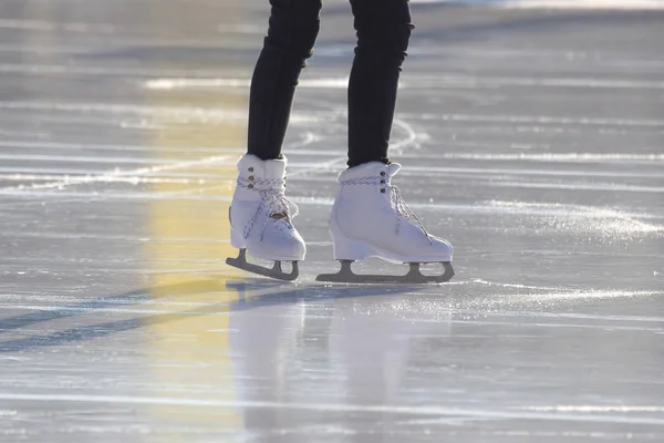 Pernas de uma menina patinação no gelo em uma pista de gelo. hobbies e lazer . — Fotografia de Stock