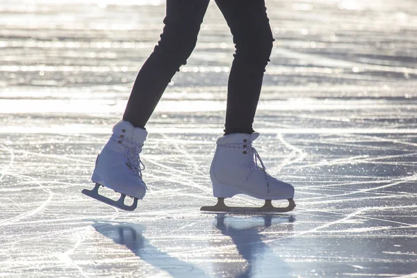 Kvinnliga ben i vita skridskor på en isbana. Sport och hobbyer. H — Stockfoto